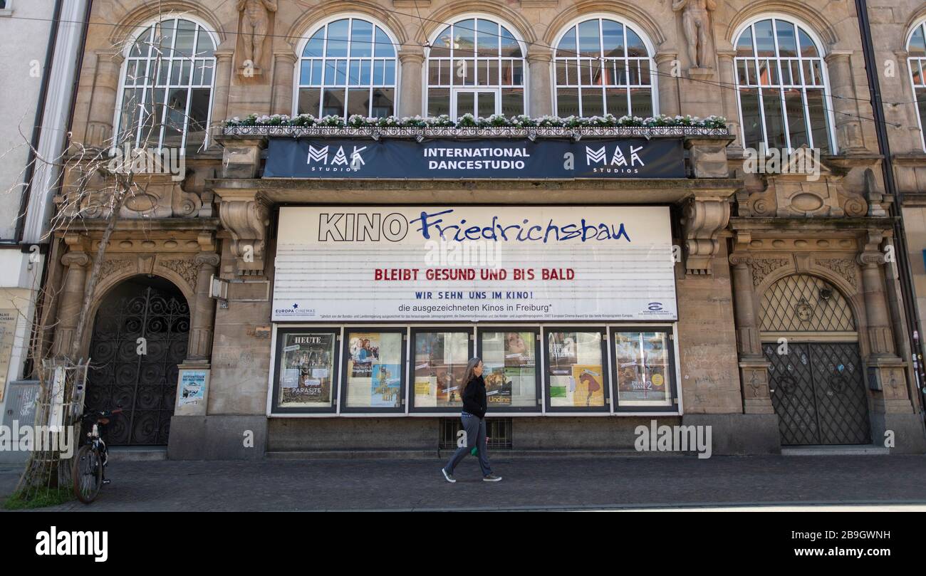 Friburgo, Germania. 24 Marzo 2020. Il cinema 'Friedrichsbau' dice addio alla pubblicità all'aperto con l'iscrizione 'Bleibt gesund und bis bald - Wir sehen uns im Kino! A causa del coronavirus, i cinema devono chiudere. Credit: Patrick Seeger/dpa/Alamy Live News Foto Stock