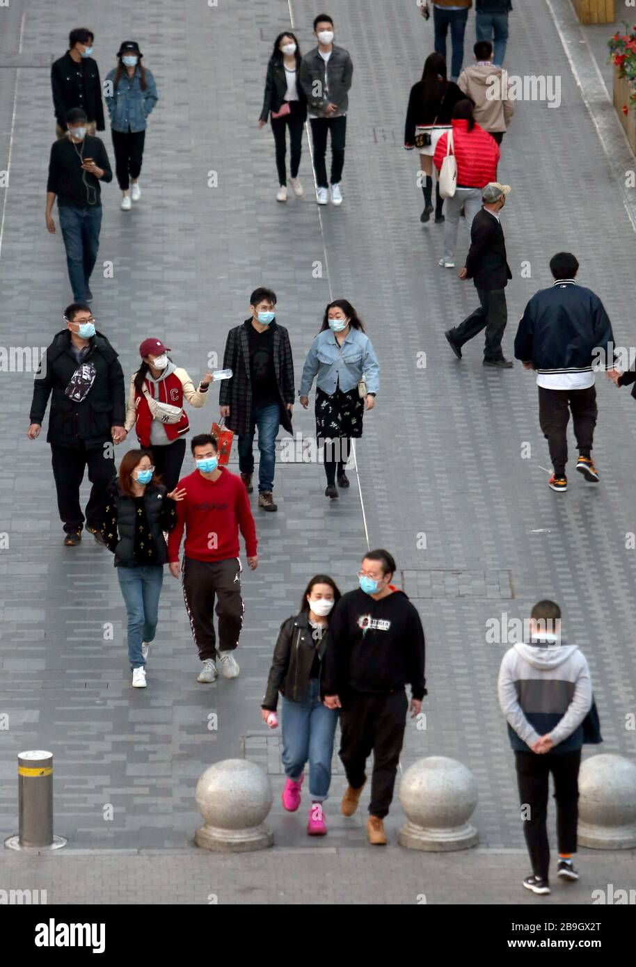 Pechino, Cina. 24 Marzo 2020. I Cinesi indossano ancora maschere facciali protettive mentre visitano un'area commerciale mentre la minaccia del coronavirus mortale (Covid-19) si affievolisce a Pechino martedì 24 marzo 2020. La Cina continua a non segnalare nuovi casi di coronavirus trasmessi localmente dall'inizio dell'epidemia di coronavirus. Foto di Stephen Shaver/UPI Credit: UPI/Alamy Live News Foto Stock