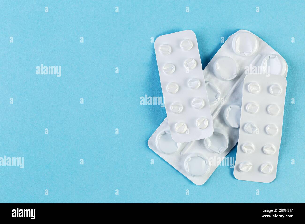 Un mucchio usato blister confezioni di pillole su sfondo blu. Blister per uso medico aperti e vuoti senza pillole vista dall'alto. Concetto medico e sanitario. Foto Stock