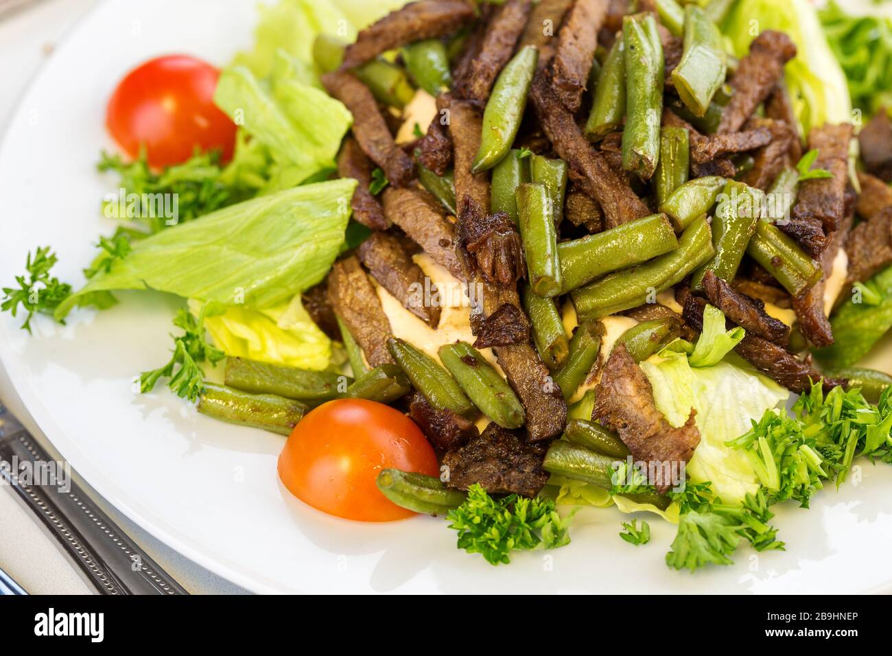 Insalata gustosa con asparagi arrostiti e manzo su un piatto bianco Foto Stock