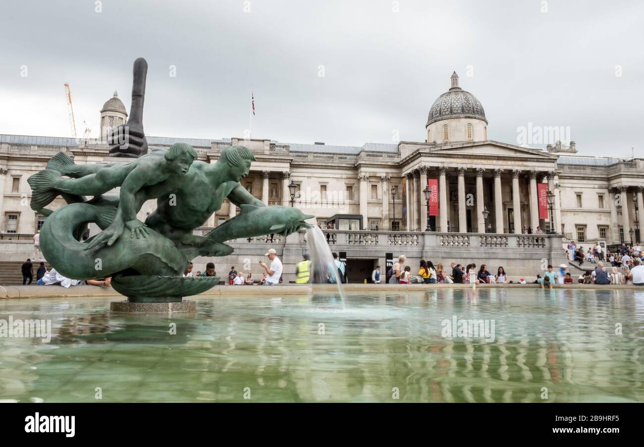 Trafalgar Square e la National Gallery. Turisti che si riungono presso le fontane nella popolare località turistica londinese. Foto Stock