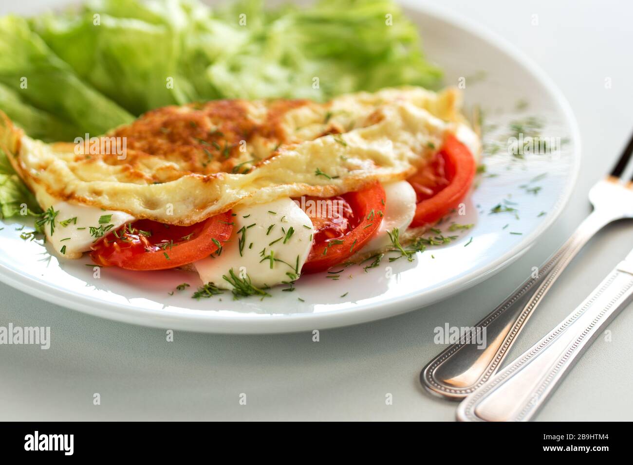 Deliziosa frittata con pomodoro, insalata e mozzarella Foto Stock