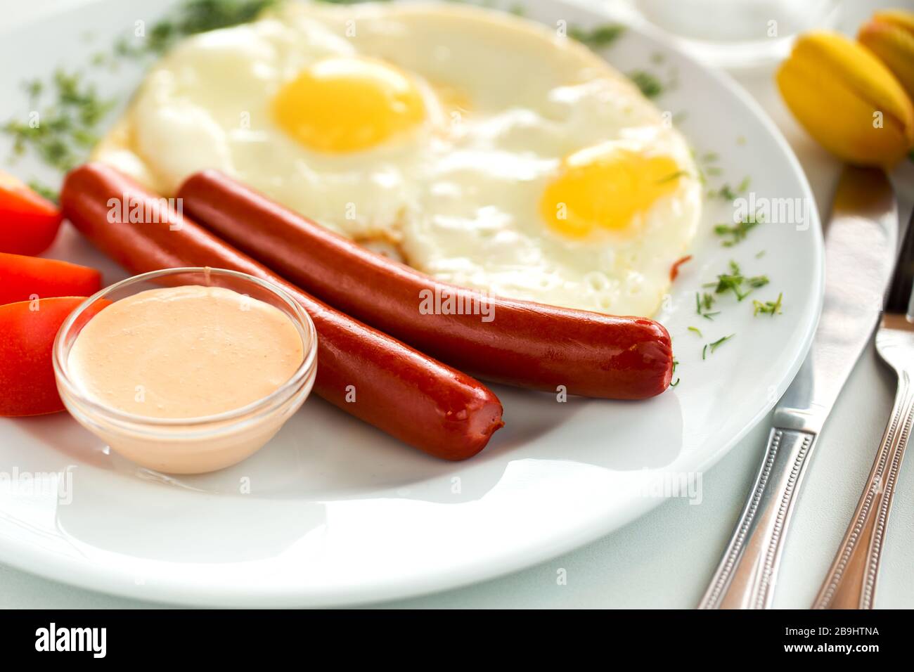 Gustose salsicce e uova fritte con pomodori Foto Stock