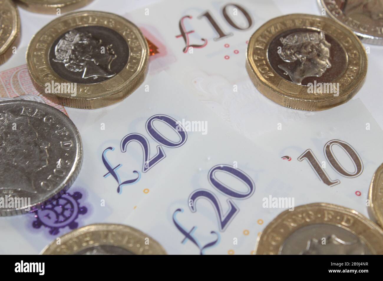 Moneta britannica monete da sterlina £1 e dieci banconote da sterlina, £10, banconote da venti sterline £20 sterline Foto Stock