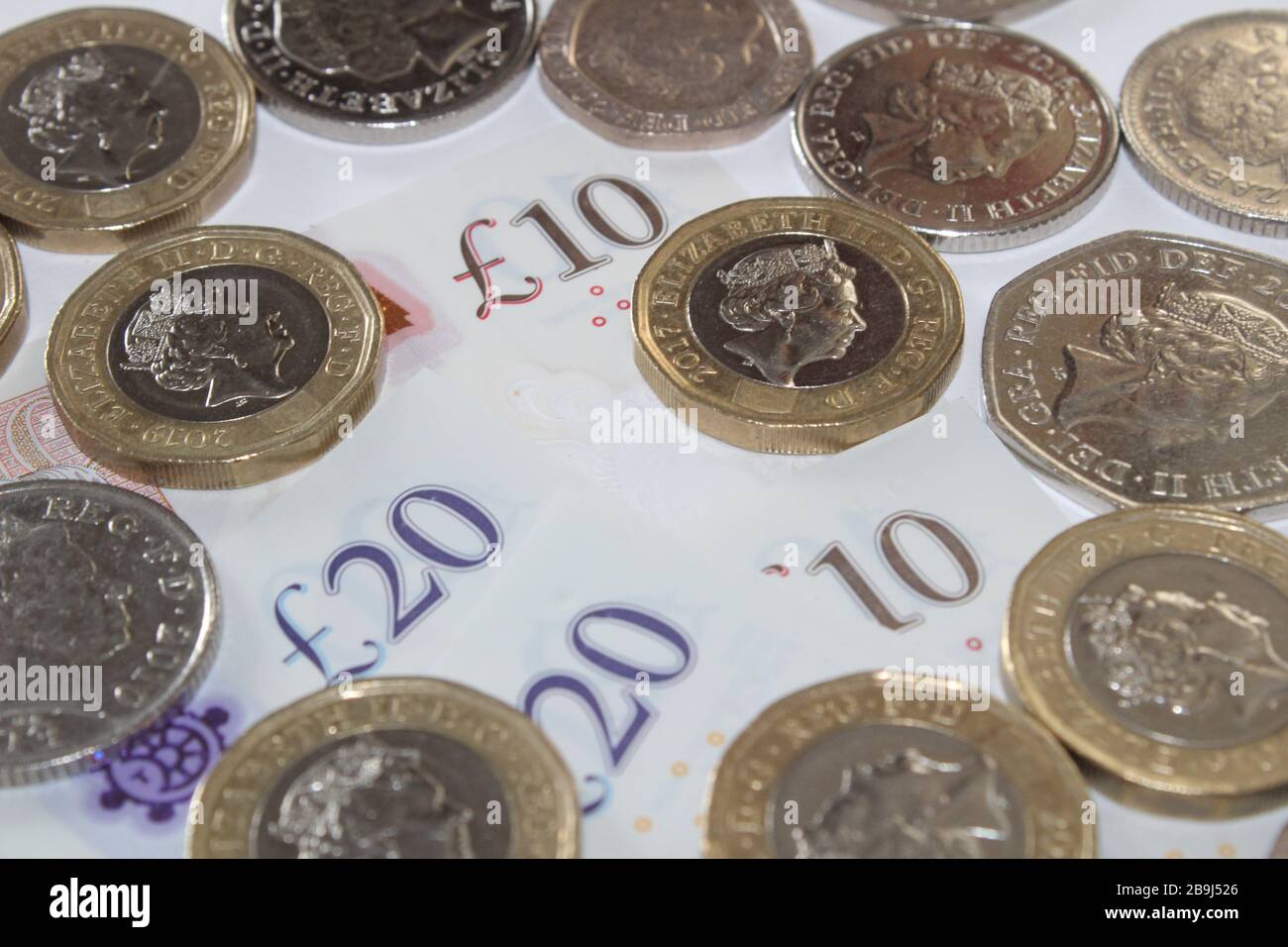 Moneta britannica monete da sterlina £1 e dieci banconote da sterlina, £10, banconote da venti sterline £20 sterline Foto Stock