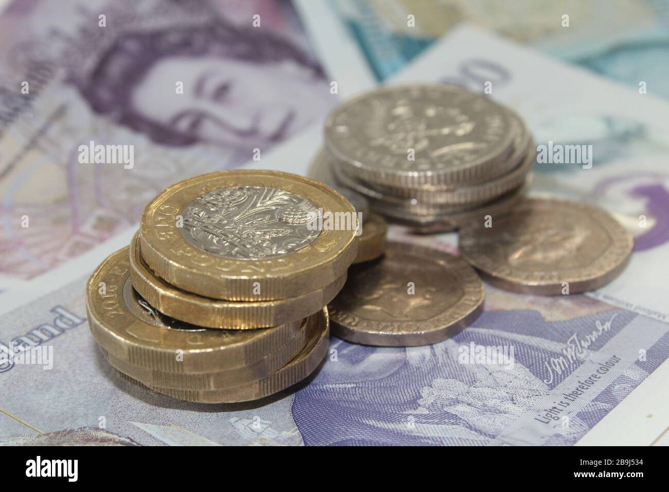Moneta britannica monete da sterlina £1 e dieci banconote da sterlina, £10, banconote da venti sterline £20 sterline Foto Stock