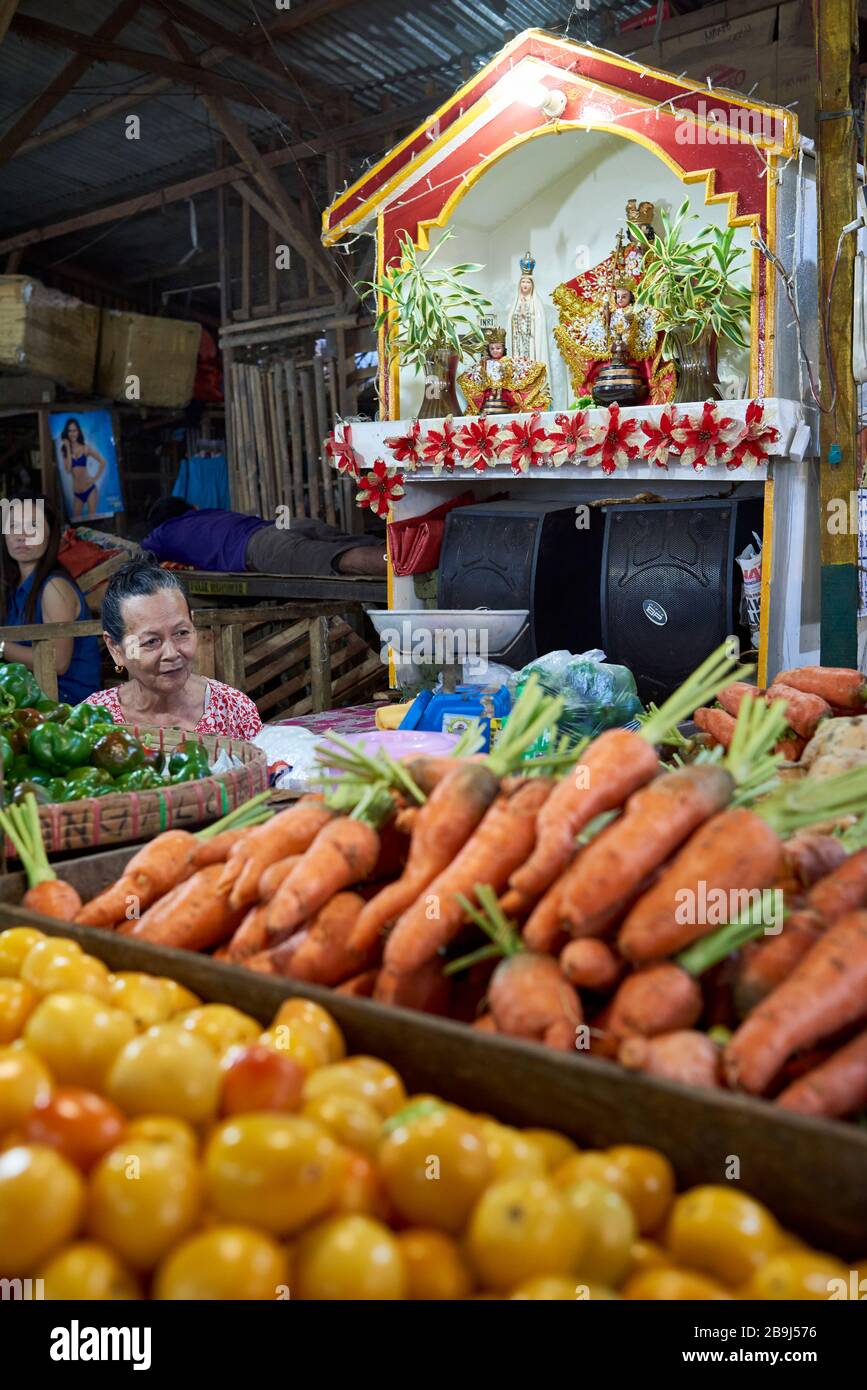 Bancarella di verdure con un altare dell'immagine di Santo Niño. Santo Niño è l'immagine più venerata per il popolo filippino cattolico. Foto Stock