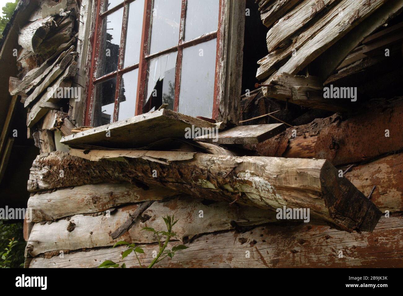 Muri rotti di vecchia casa di legno dilapidato che sta cadendo giù. Foto Stock