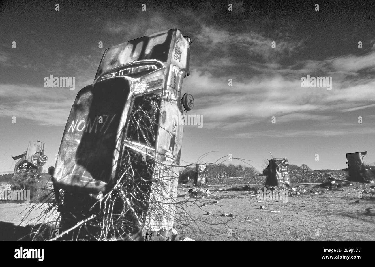 Carhenge a Pollock Park, Glasgow 1994. Una collezione di auto arrugginite rovesciate e coperte di graffiti come protesta per la costruzione dell'autostrada M77. Foto Stock