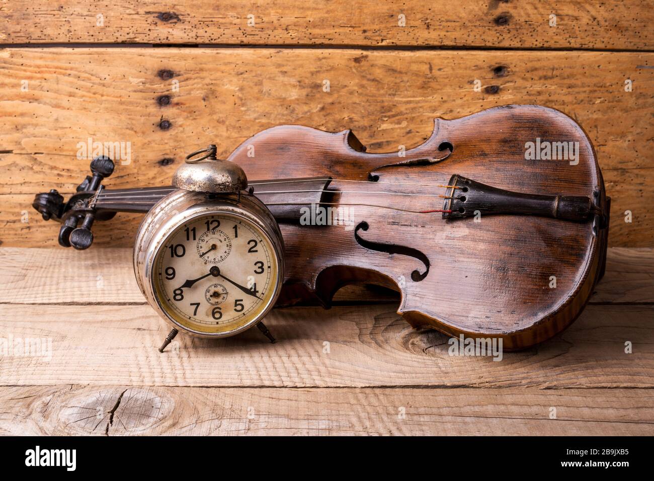 Orologio antico e vecchio violino su tavolo in legno d'epoca - fuoco selettivo, spazio copia Foto Stock