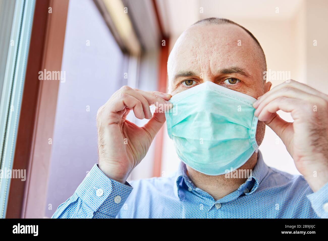 Covid-19 paziente in quarantena con maschera facciale a casa Foto Stock