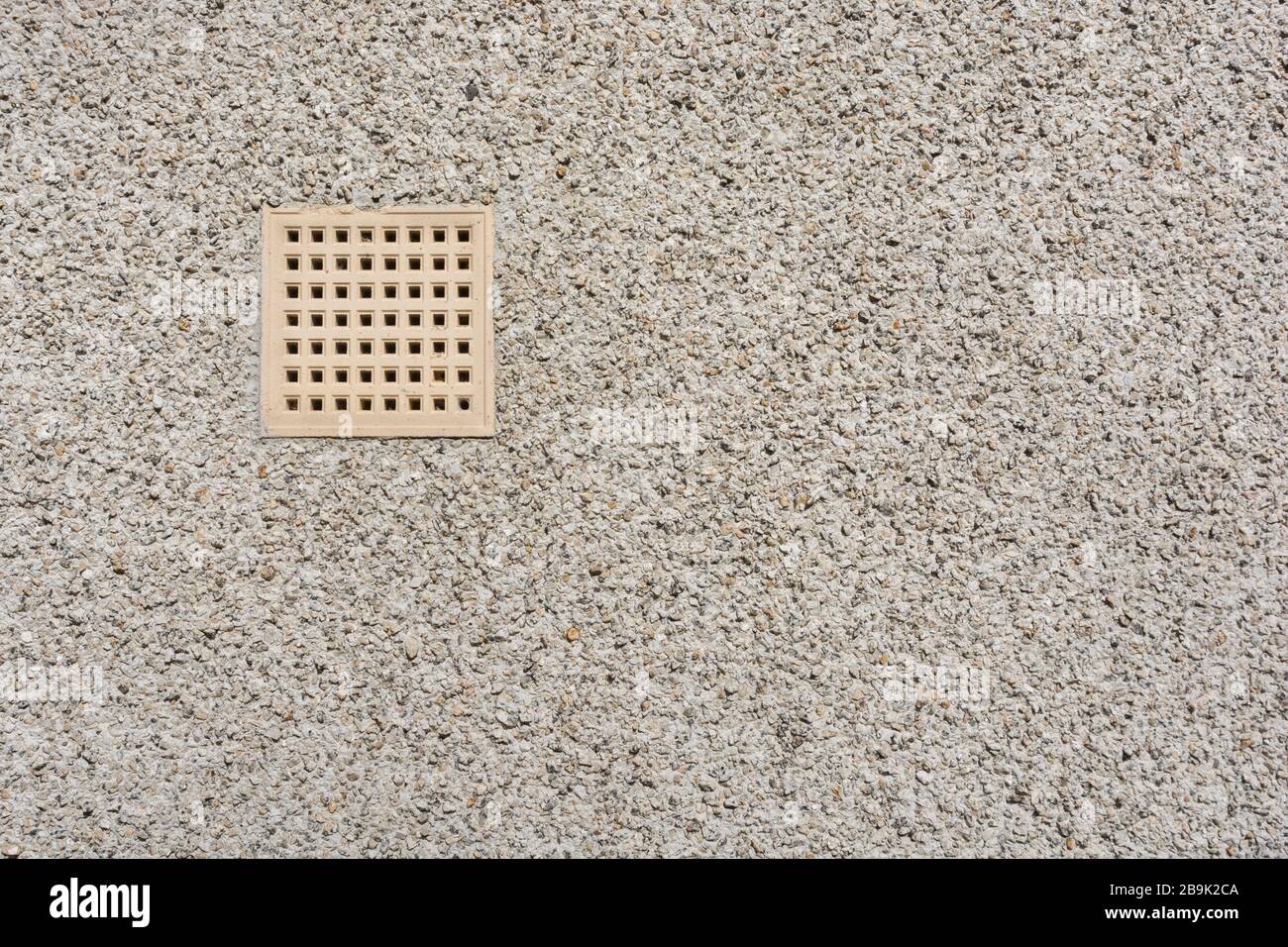 Pavimento in cotto chiaro per ventilazione aria sul lato di un muro di pietra tratteggiato. Metafora foro rotondo pioli quadrato. Foto Stock