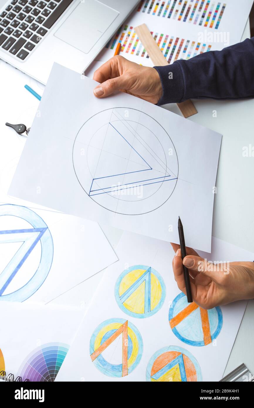Il designer disegna gli schizzi del logo del marchio. Foto Stock