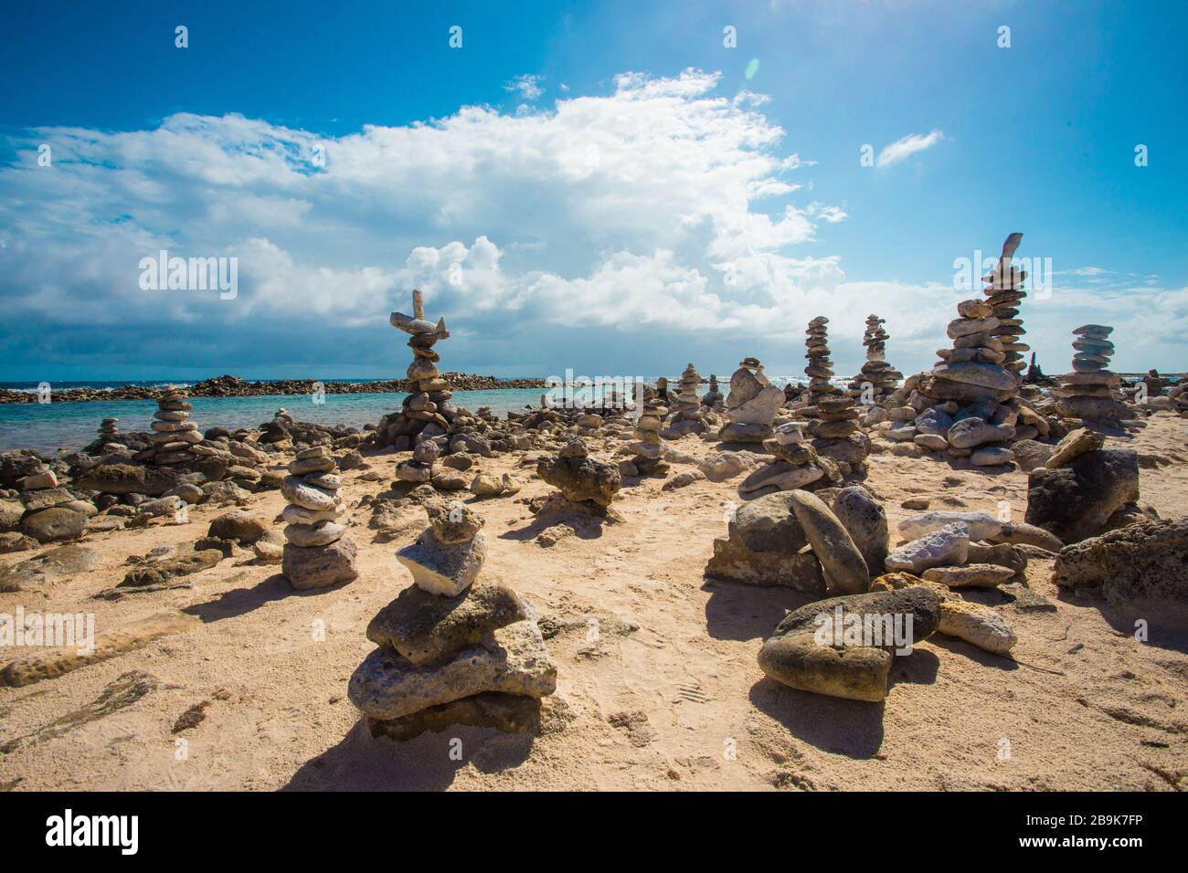 Rocce impilate si bilanciano sulla spiaggia rocciosa di Aruba Foto Stock