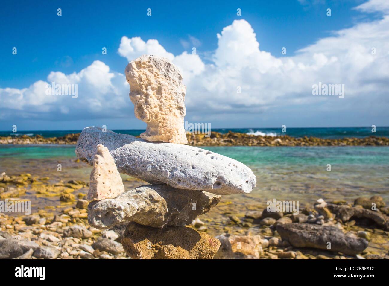 Rocce impilate si bilanciano sulla spiaggia rocciosa di Aruba Foto Stock