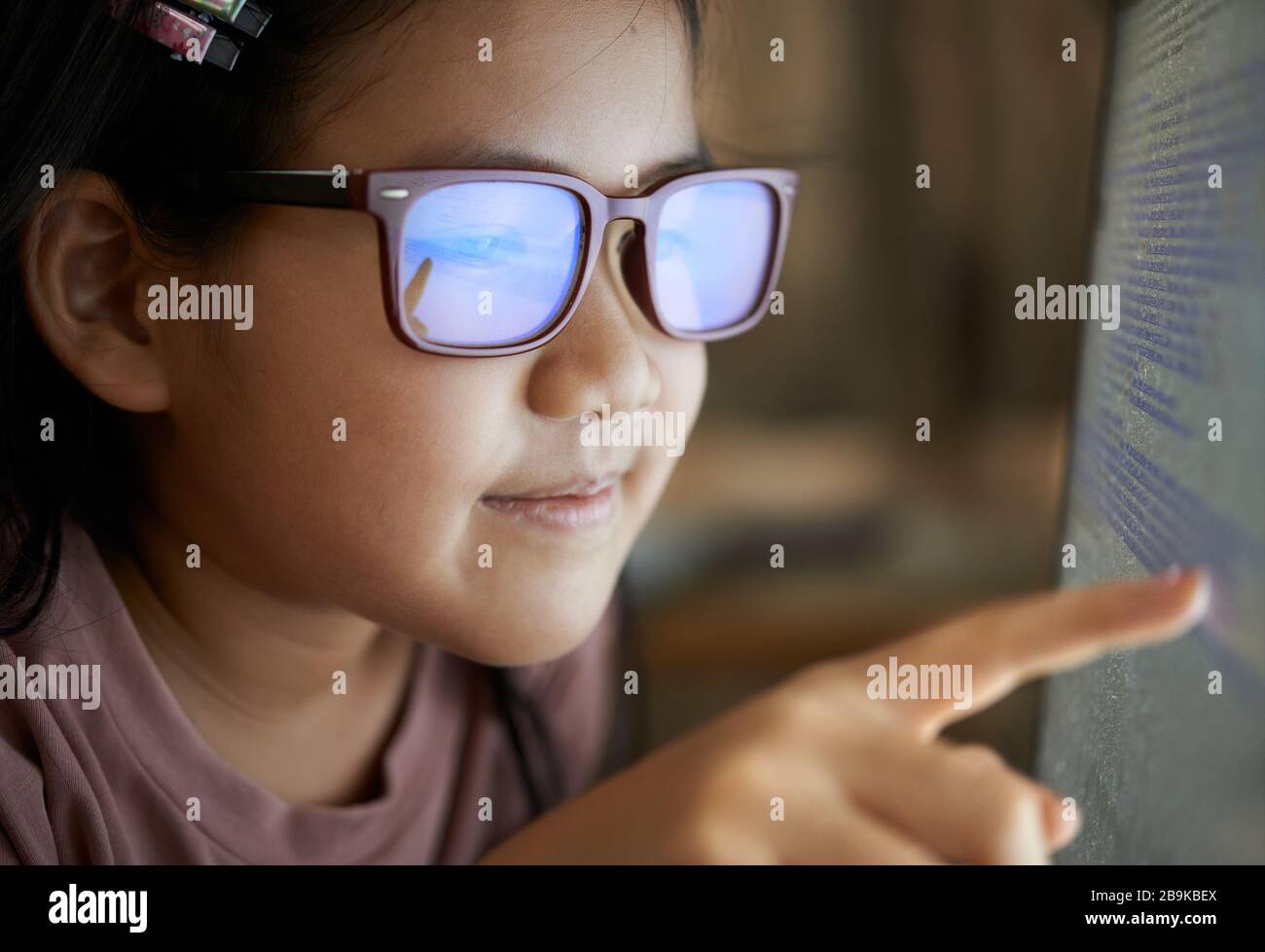 Vista ravvicinata di una ragazza che legge il codice sul monitor Foto Stock