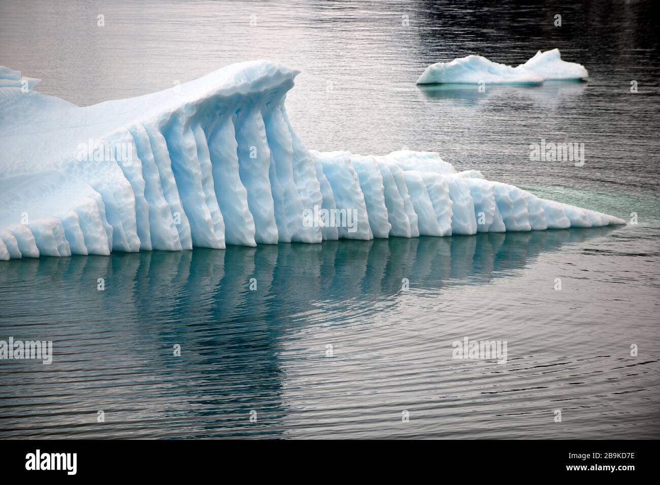 I motivi naturali su un iceberg si riflettono nel mare. Foto Stock
