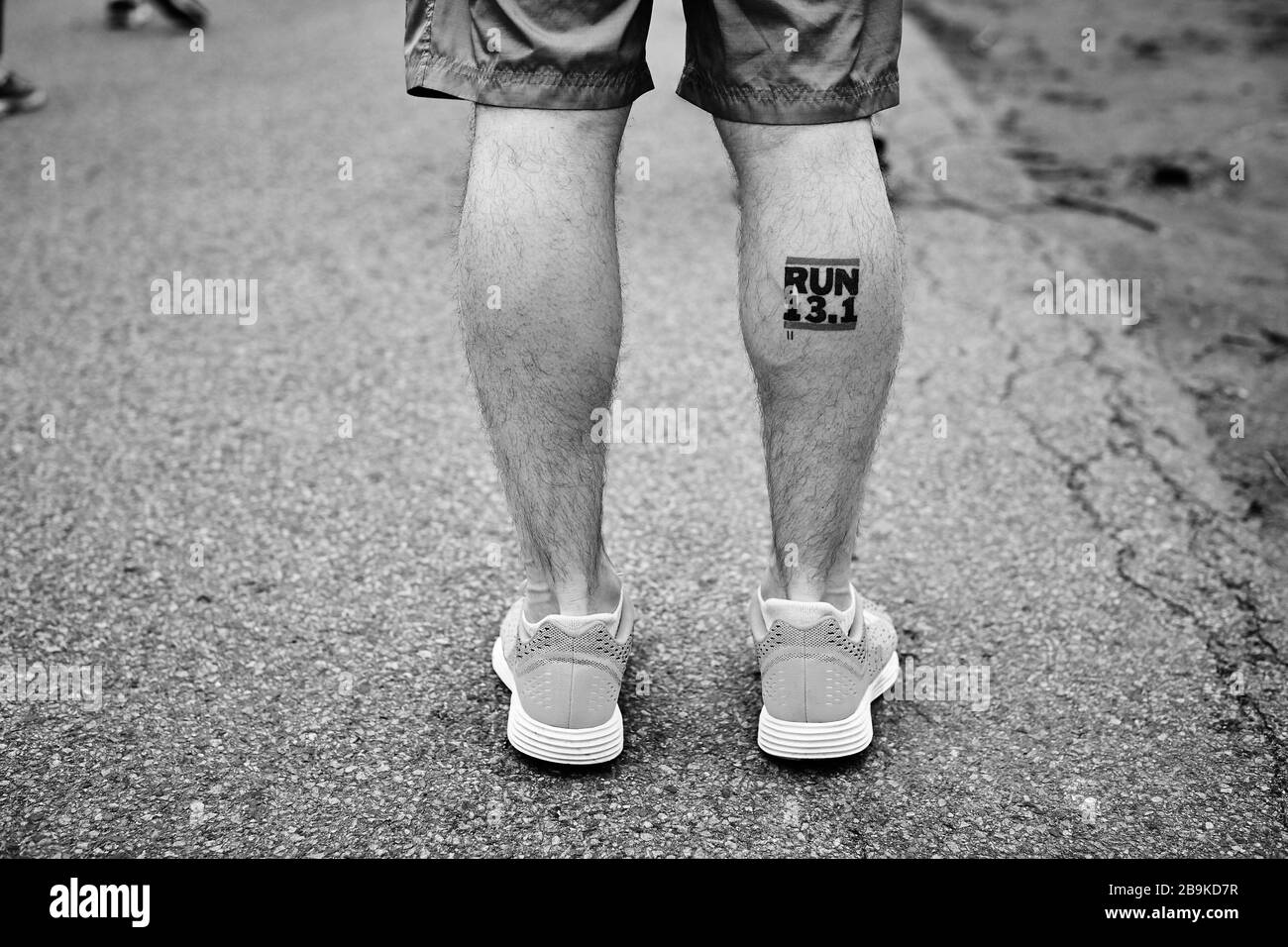 Gambe del corridore con una mezza maratona, CORSA 13.1, tatuaggio. Foto Stock