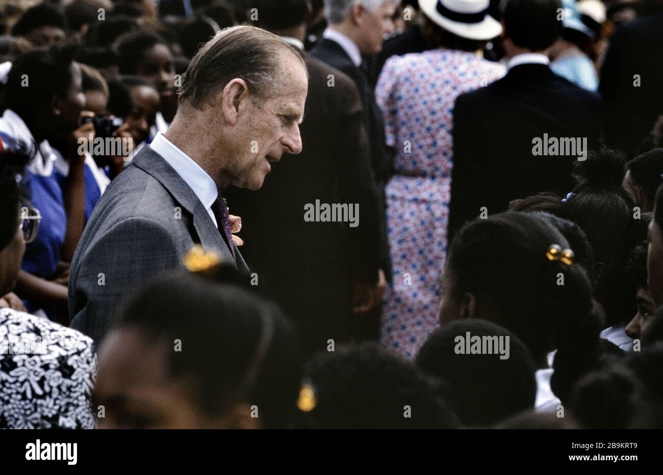 Il Principe Filippo, Duca di Edimburgo, parla con gli studenti dopo aver partecipato alla cerimonia di posa della pietra del Queen's College per il nuovo edificio della scuola. Barbados, Caraibi. 1989 Foto Stock