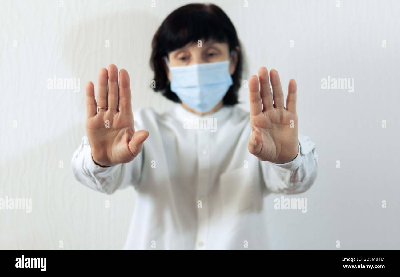 Quarantena del coronavirus e inquinamento atmosferico pm2.5 concetto. Vecchia donna malata che indossa maschera respiratore blu per proteggere con braccio allungato. Wuhan, Cina ep Foto Stock