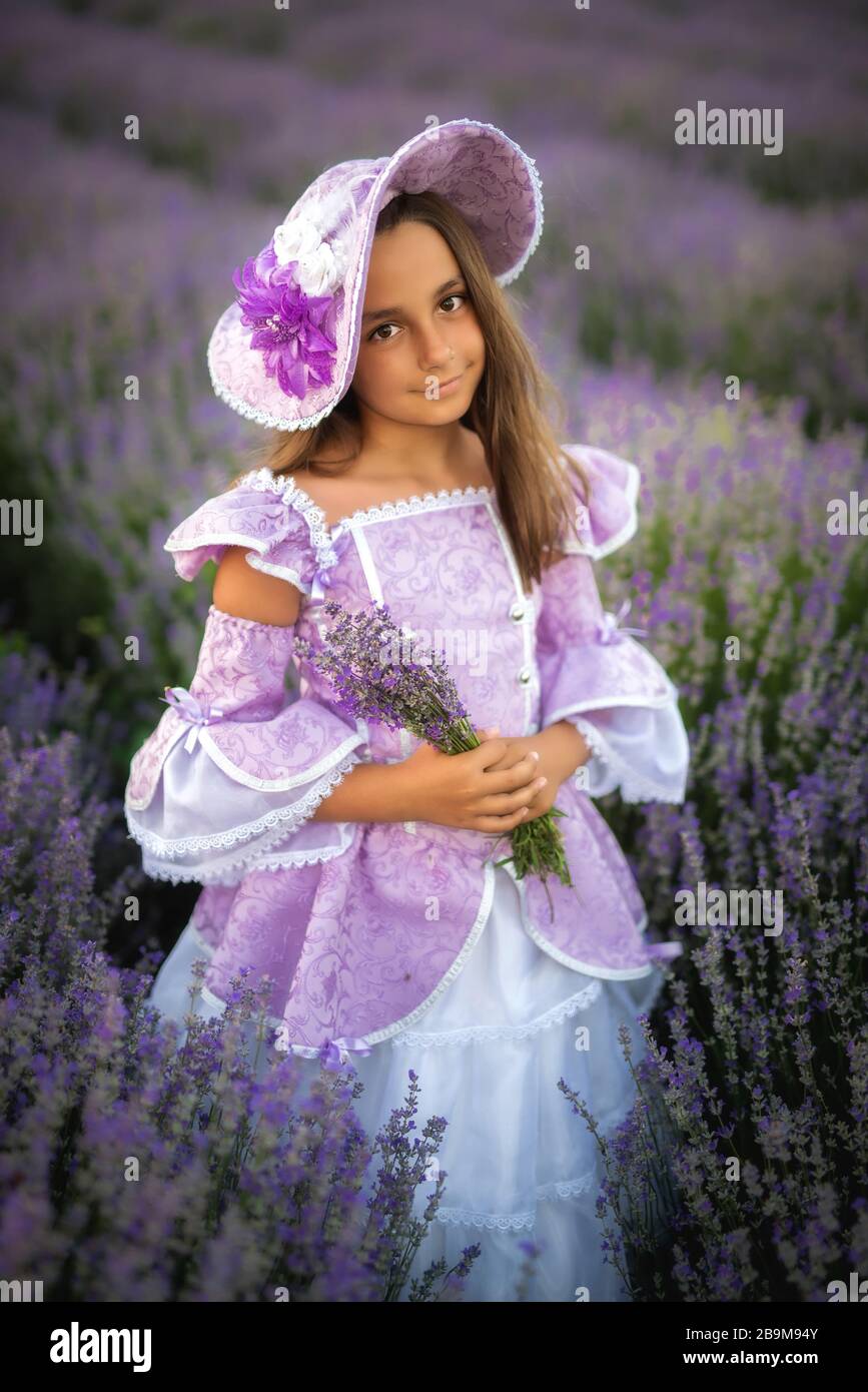 bambina vestita come principessa in un campo di lavanda Foto Stock