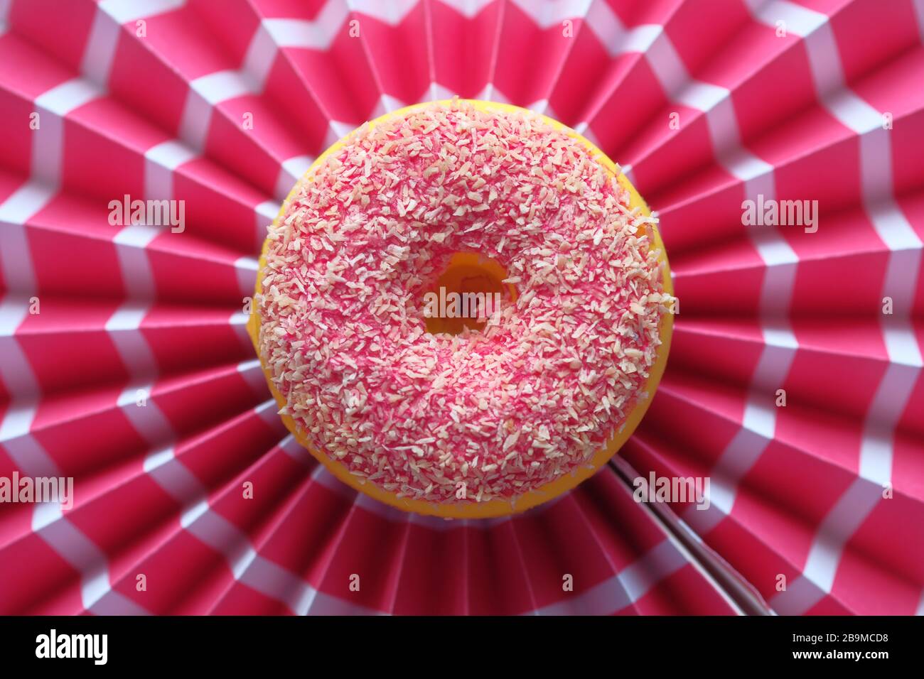 Ciambella con sfondo rosso aspersato, vista dall'alto Foto Stock