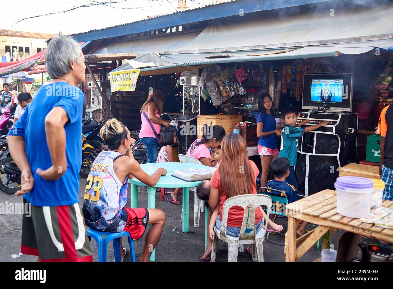 Gruppo di persone che giocano con un gioco di karaoke per le strade del mercato pubblico del carbonio. Foto Stock