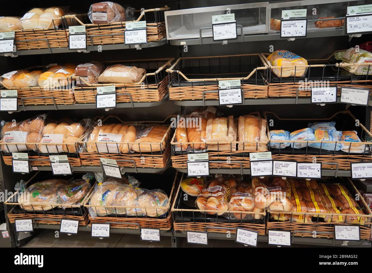 Pane fresco diverso sugli scaffali in panetteria. Interno di un negozio di alimentari moderno che mostra la navata del pane con una varietà di pane preconfezionato ava Foto Stock