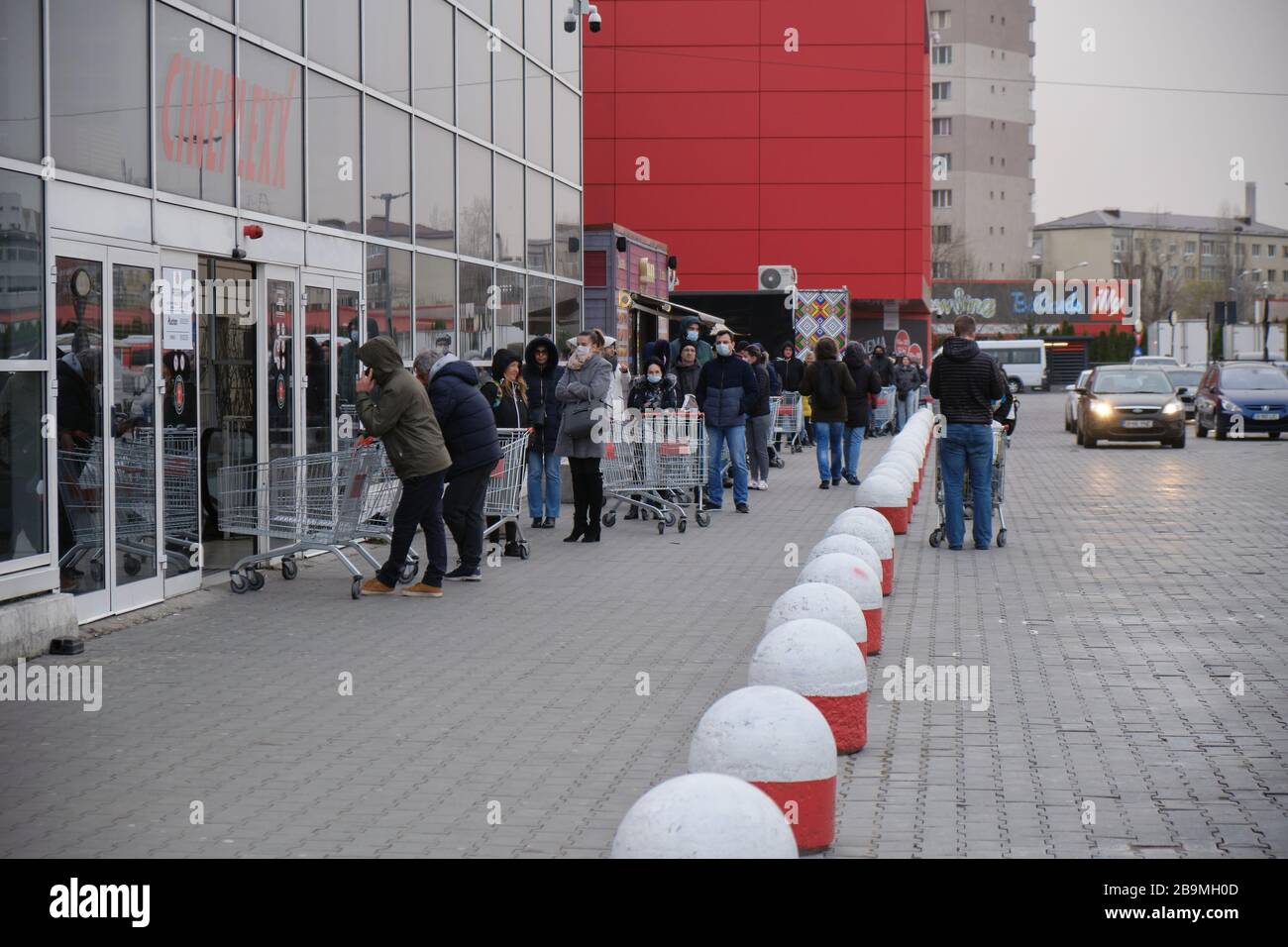 Bucarest, Romania - 24 marzo 2020: Gli acquirenti si trovano in coda fuori da un supermercato, dopo l'annuncio di un blocco Coronavirus. Foto Stock