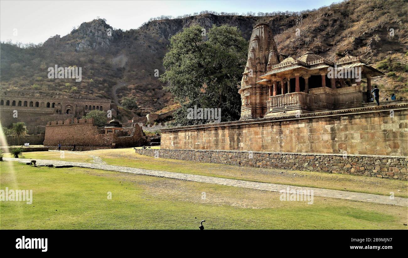 Vista remota di luce del forte di nahargarh rovinato con il tempio impressionante all'ingresso situato a Jaipur, Rajasthan, India Foto Stock