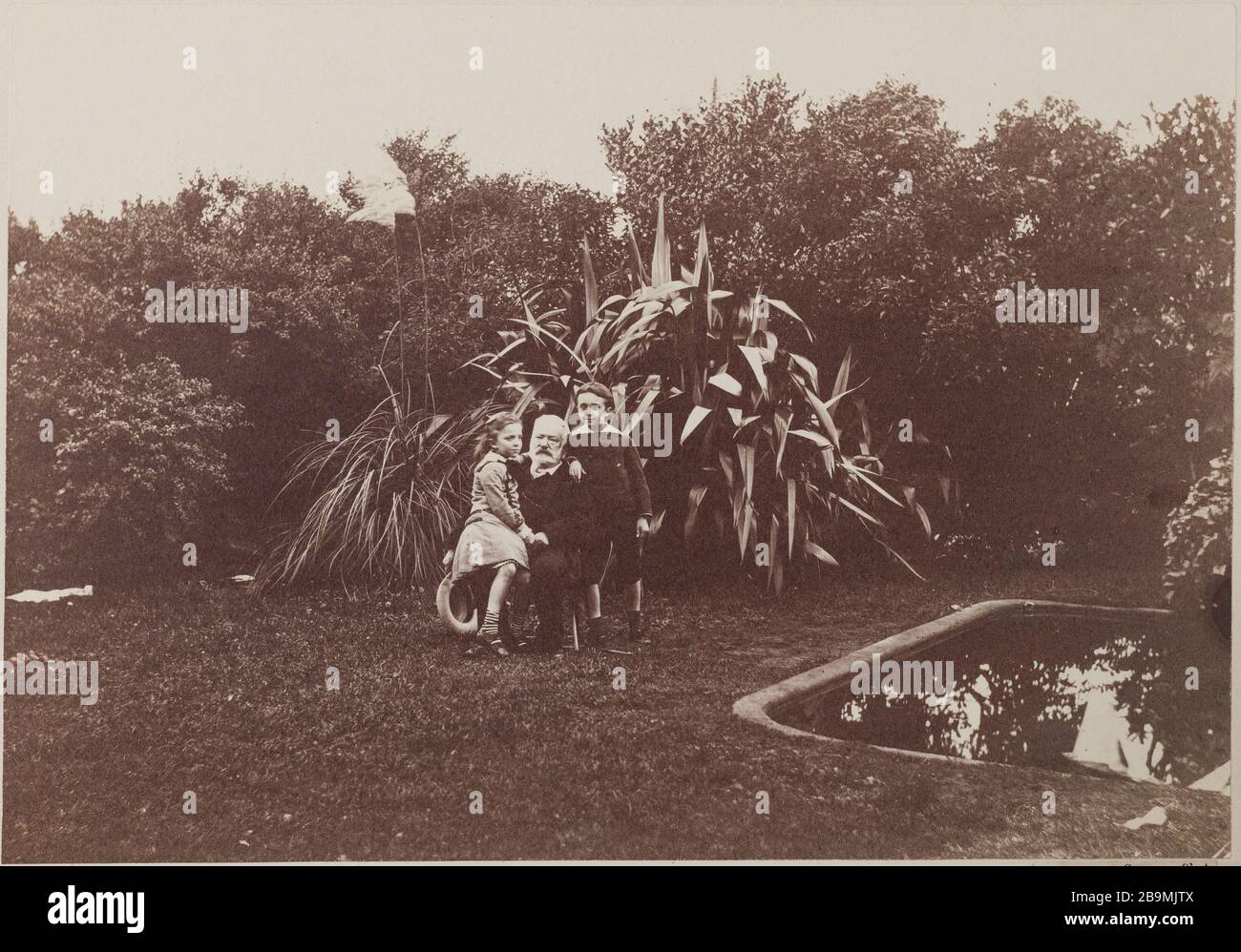 Victor Hugo con i suoi nipoti George e Jeanne nel giardino della casa di Hauteville Victor Hugo avec ses petits-enfants Georges et Jeanne dans le jardin de Hauteville House. Albuminé di papier. Photographie de Valentin Guillon, 1878. Parigi, Maison de Victor Hugo. Foto Stock