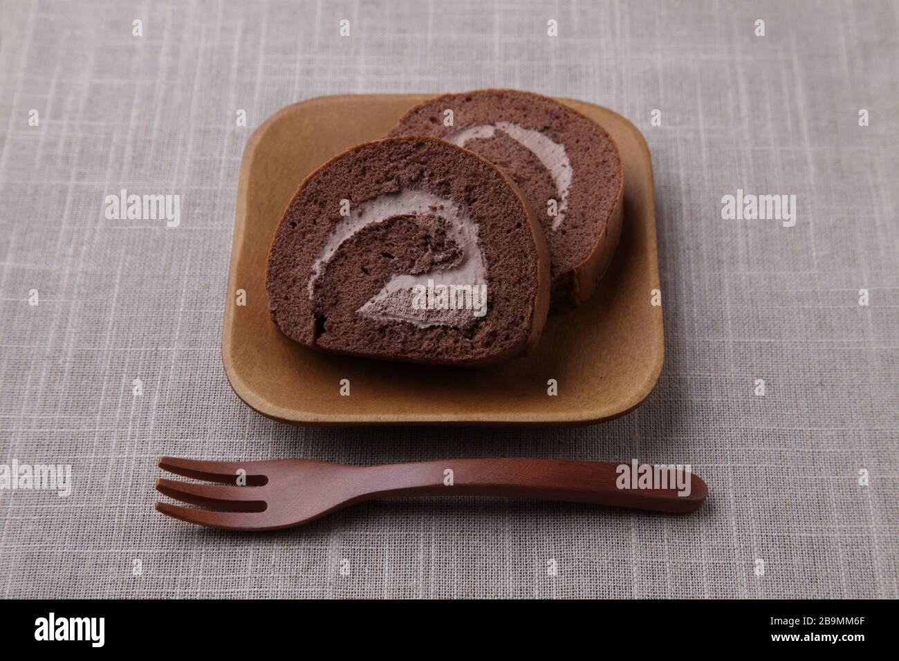 torte al cioccolato in rotolo su piastra isolata su panno da tavolo Foto Stock