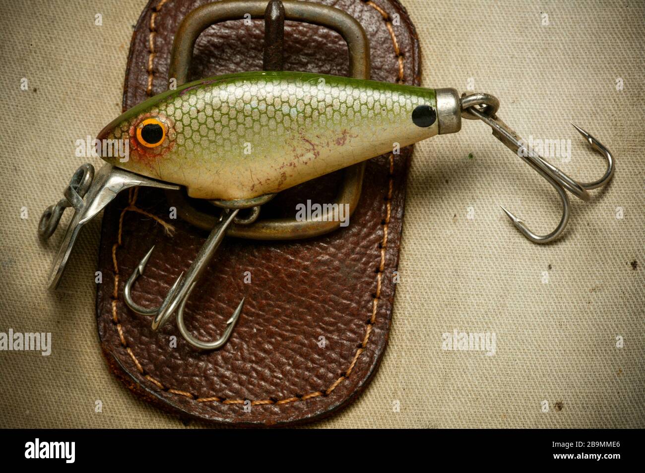 Un esempio di esca di pesca d'epoca dotata di ganci per gli alti, possibilmente realizzati da Woods Mfg, esposti su una vecchia borsa da pesca. Esche come queste sono Foto Stock