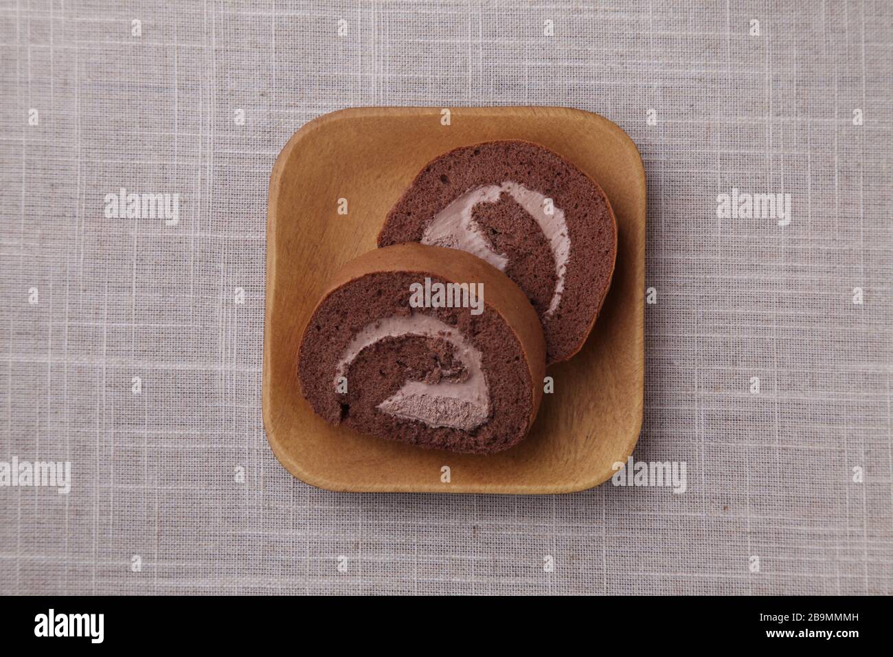 torte al cioccolato in rotolo su piastra isolata su panno da tavolo Foto Stock
