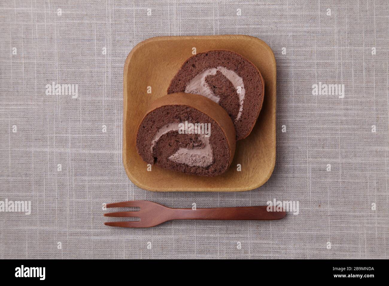 torte al cioccolato in rotolo su piastra isolata su panno da tavolo Foto Stock