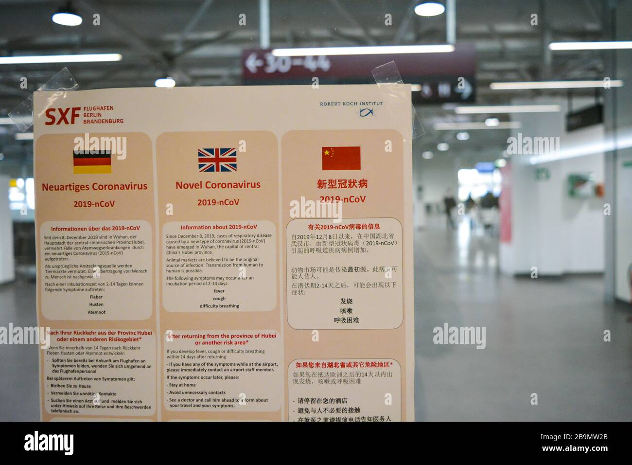 Aeroporto Schonefeld di Berlino SXF, Germania - 02/01/20: Avviso pubblico su Coronavirus COVID-19. Scritto in tedesco, inglese, cinese a vuoto Foto Stock