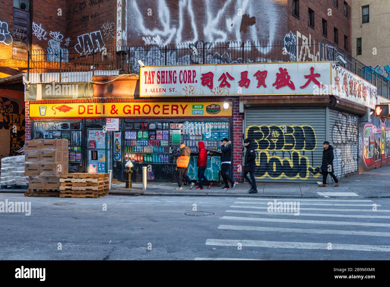 Quartiere Chinatown a Lower Manhattan, New York City, vista diurna che mostra i negozi della strada con lettere cinesi, arte Graffiti e persone a piedi Foto Stock