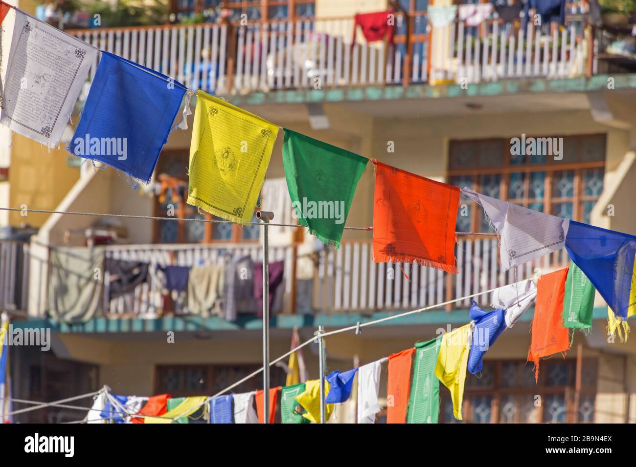 Primo piano delle bandiere di preghiera tibetane nella costruzione a Dharamshala, India Foto Stock