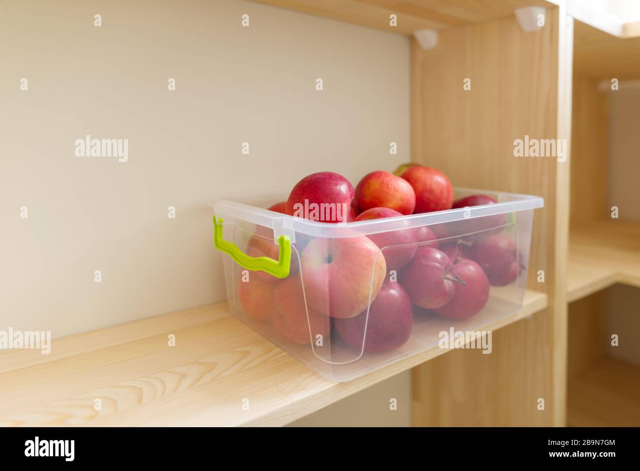 Conservazione degli alimenti, scaffali in legno nella dispensa con contenitori di mele. Foto Stock