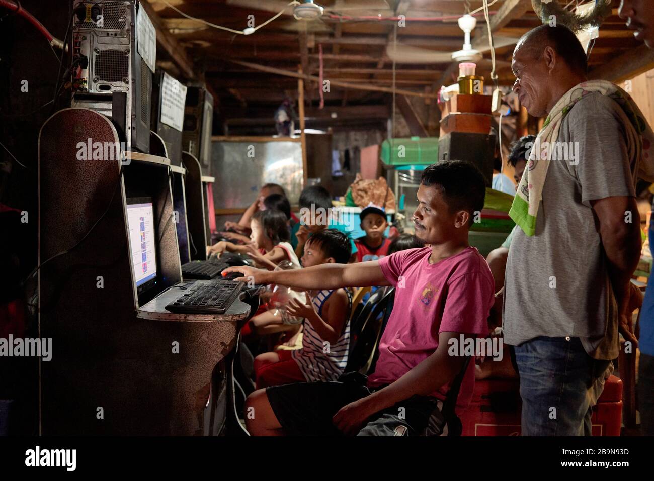 Gruppo di persone che giocano a videogiochi in una sala arcade improvvisata nel mercato pubblico Carbon. Foto Stock