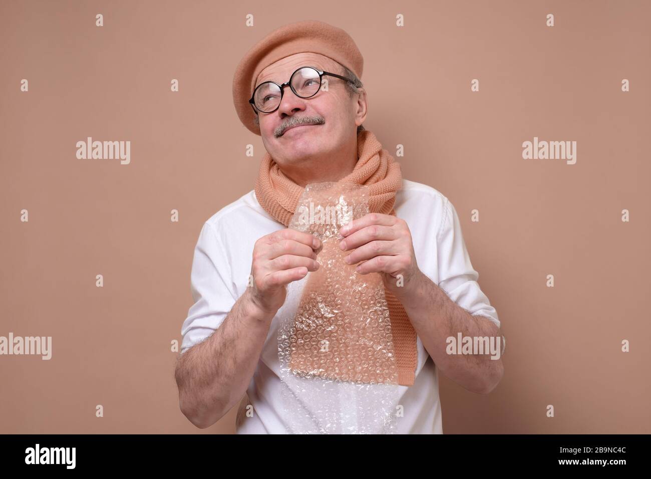 uomo che tiene un pezzo di bolla avvolge in mano cercando di rilassarsi e non ti preoccupare. Foto Stock