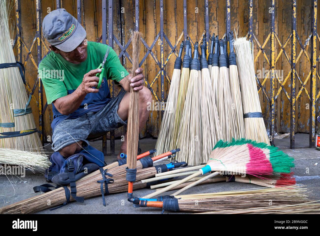 Uomo che fa scopa per le strade del mercato pubblico del carbonio. Foto Stock
