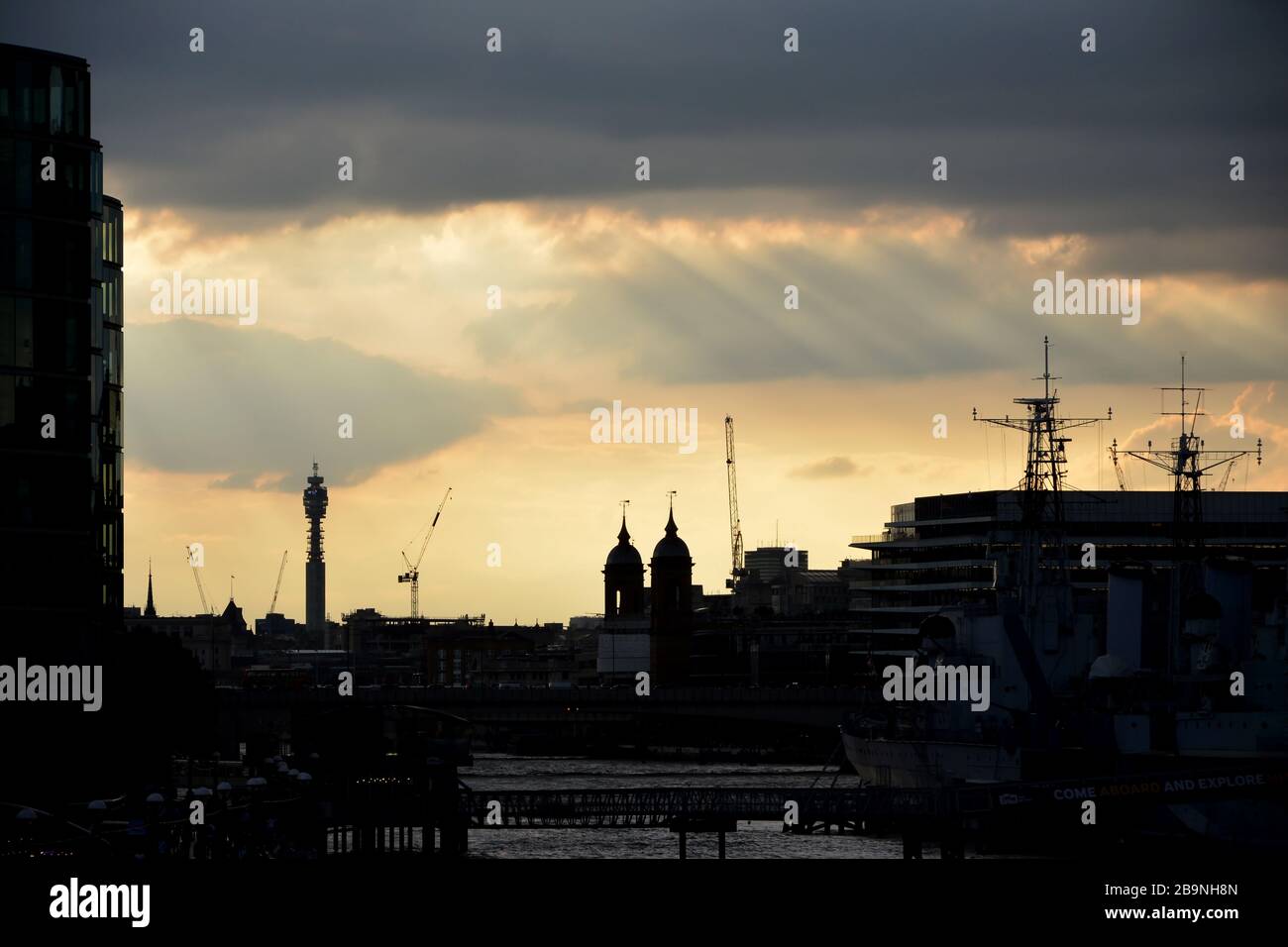 Una vista del tramonto dall'area della Torre di Londra che guarda verso ovest. Le guglie della stazione di Cannon Street e la torre BT sono visibili Foto Stock