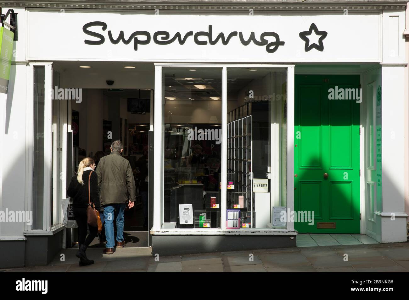 Un pedone cammina in un ramo di Superdrug a Guildford, Surrey U.K. Venerdì 20 marzo 2020 Foto Stock