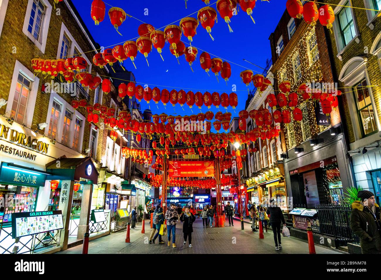 Lanterne cinesi rosse e gialle appese sopra una strada di notte a China Town, Londra, Regno Unito Foto Stock