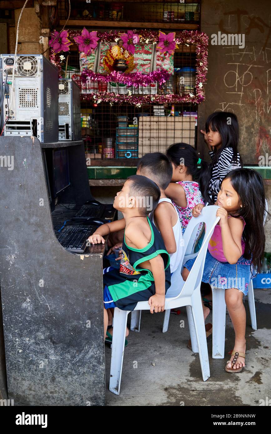 Gruppo di bambini che giocano a videogiochi per le strade del mercato pubblico Carbon. Foto Stock