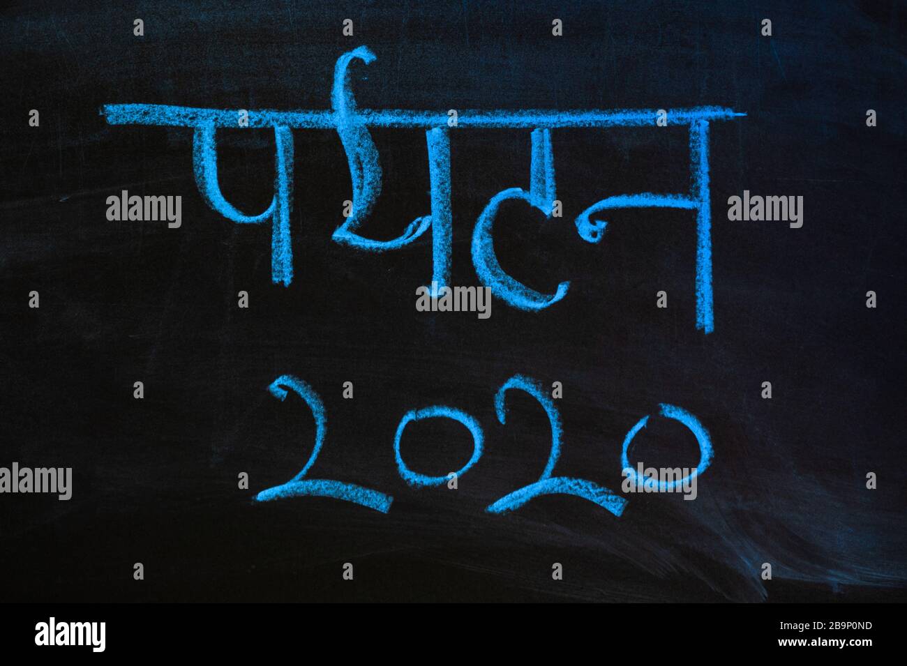 Parola 'turismo 2020' a Hindi. L'iscrizione 'Tourism 2020' su una lavagna nera con gesso blu Foto Stock