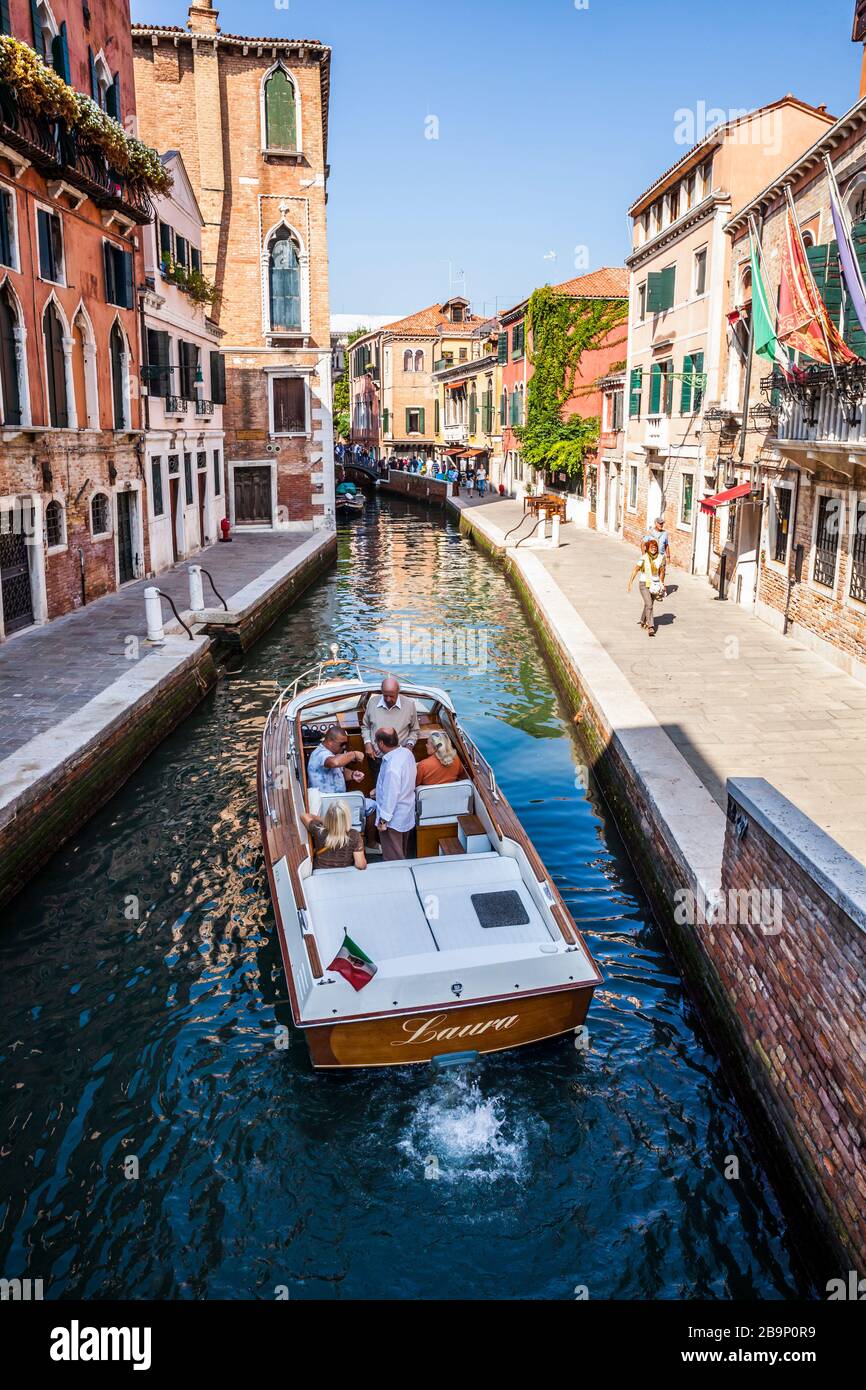 Persone in barca in un canale, Venezia, Italia. Foto Stock