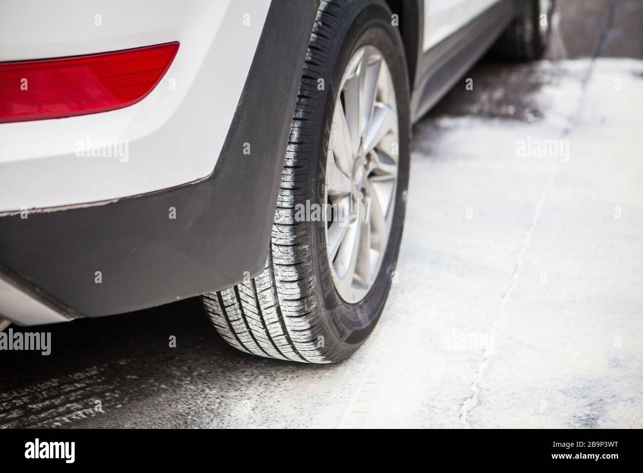 Auto ruota posteriore destra in una strada innevata Foto Stock