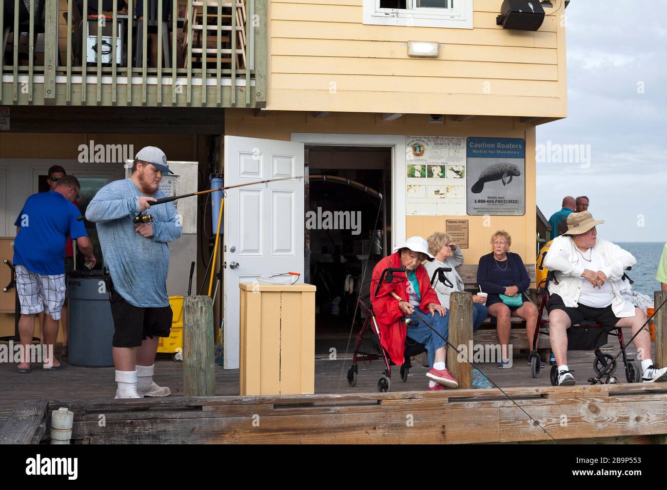 Un uomo pesca fuori di un molo sull'isola di Anna Maria, Florida, Stati Uniti. Foto Stock